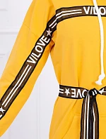 Šaty zdobené stuhou a nápismi v horčicovej farbe