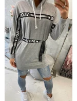 Šaty zdobené stuhou s nápisom šedá