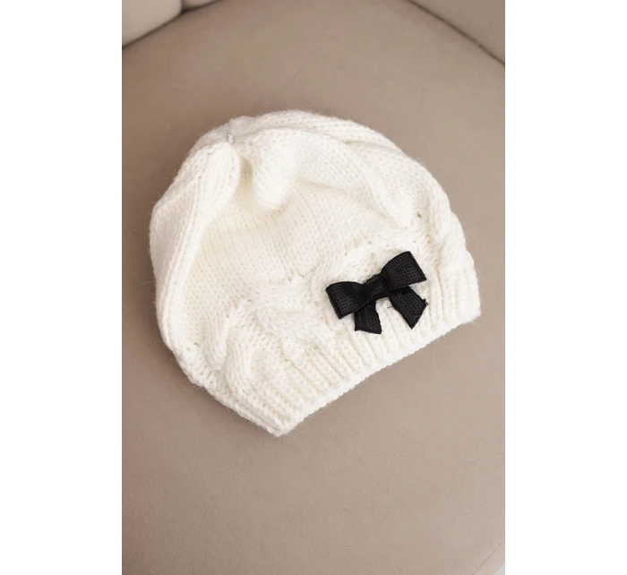 Dámska zimná čiapka s ozdobnou mašľou a vrkočovým vzorom K438 ecru Dámska zimná čiapka s ozdobnou mašľou a vrkočovým vzorom K438 ecru