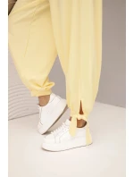 Dámske nohavice so širokými nohavicami a viazaním v spodnej časti žltej farby