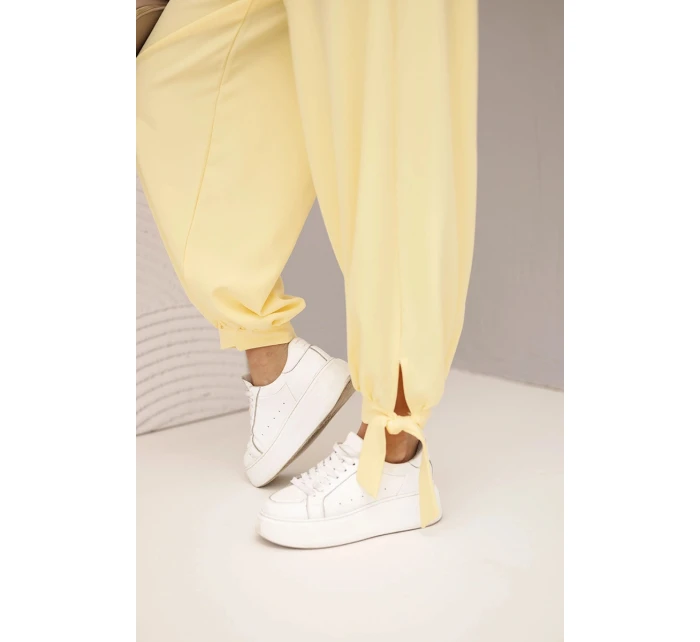 Dámske nohavice so širokými nohavicami a viazaním v spodnej časti žltej farby