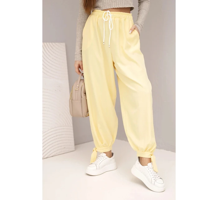 Dámske nohavice so širokými nohavicami a viazaním v spodnej časti žltej farby