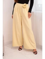Dámske elegantné nohavice so širokými nohavicami a ozdobným kvetom žltej farby