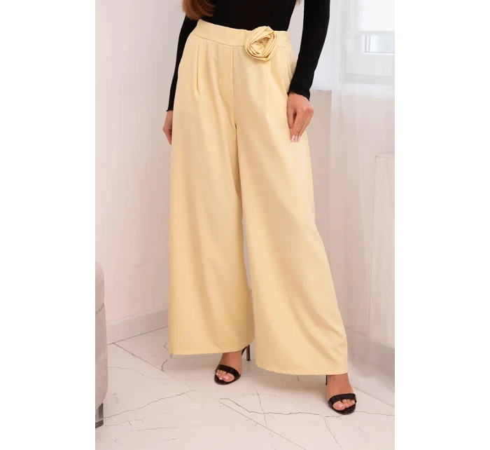 Dámske elegantné nohavice so širokými nohavicami a ozdobným kvetom žltej farby