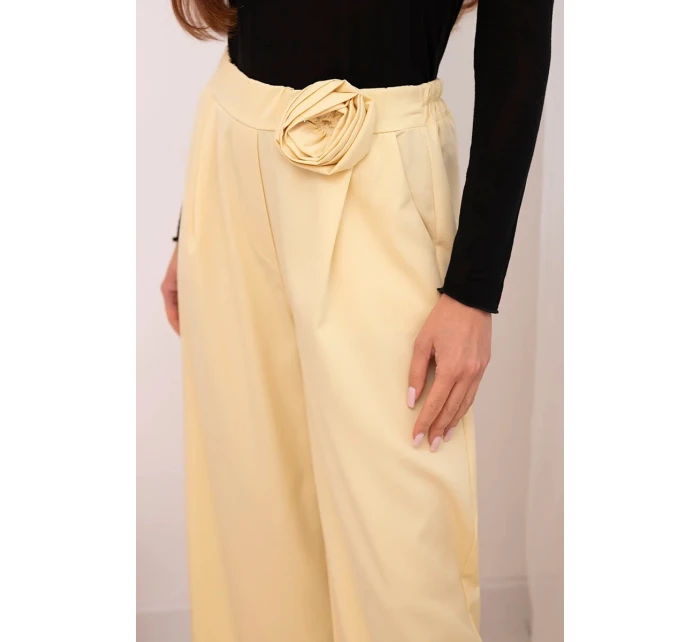 Dámske elegantné nohavice so širokými nohavicami a ozdobným kvetom žltej farby