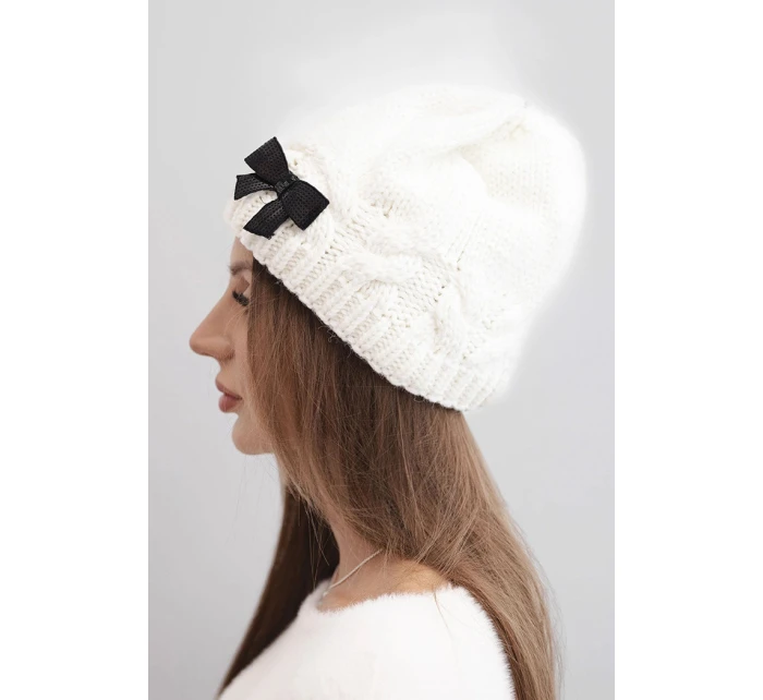 Dámska zimná čiapka s ozdobnou mašľou a vrkočovým vzorom K438 ecru Dámska zimná čiapka s ozdobnou mašľou a vrkočovým vzorom K438 ecru