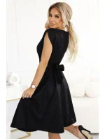 SCARLETT Černé dámské rozšířené šaty s přeloženým obálkovým výstřihem a páskem model 20850667 - numoco SCARLETT Černé dámské rozšířené šaty s přeloženým obálkovým výstřihem a páskem model 20850667 - numoco