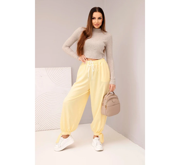 Dámske nohavice so širokými nohavicami a viazaním v spodnej časti žltej farby