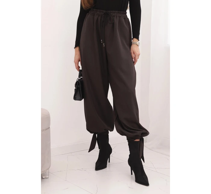 Dámske nohavice so širokými nohavicami a viazaním v spodnej časti hnedej farby Dámske nohavice so širokými nohavicami a viazaním v spodnej časti hnedej farby