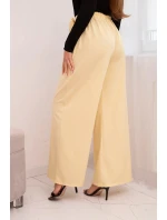 Dámske elegantné nohavice so širokými nohavicami a ozdobným kvetom žltej farby
