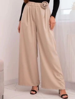 Dámske elegantné nohavice so širokými nohavicami a ozdobným kvetom béžovej farby