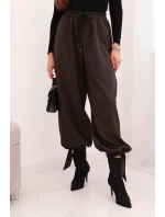 Dámske nohavice so širokými nohavicami a viazaním v spodnej časti hnedej farby Dámske nohavice so širokými nohavicami a viazaním v spodnej časti hnedej farby