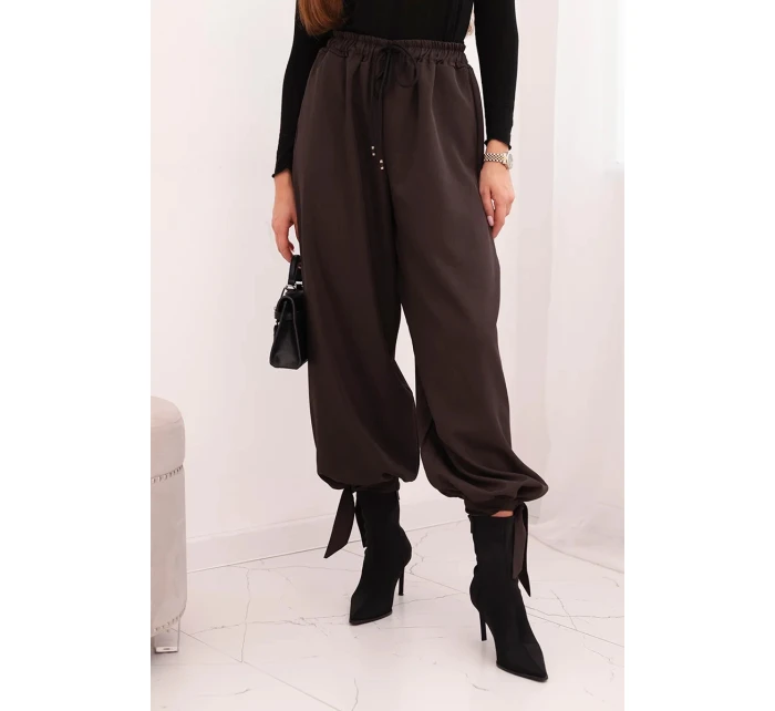 Dámske nohavice so širokými nohavicami a viazaním v spodnej časti hnedej farby Dámske nohavice so širokými nohavicami a viazaním v spodnej časti hnedej farby